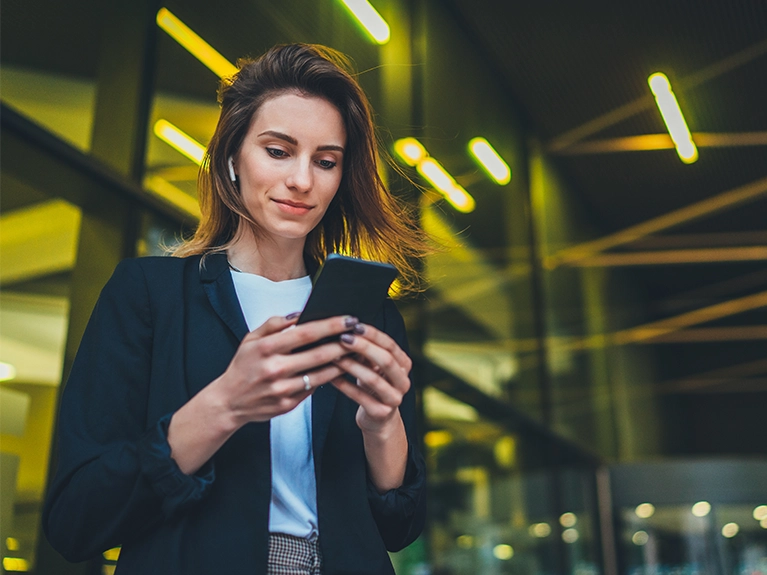 Mulher jovem, profissional de rela&ccedil;&otilde;es p&uacute;blicas, segurando um telefone celular