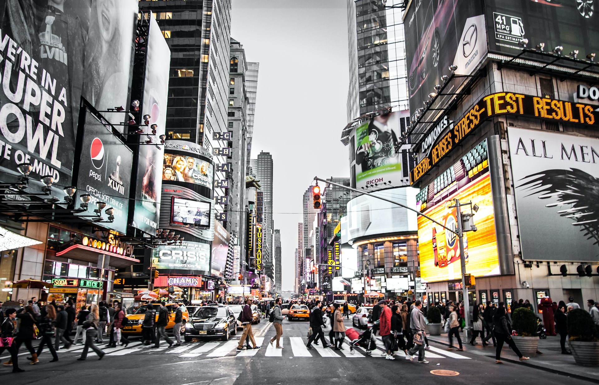 A group of pedestrians crosses the street in New York City's Times Square