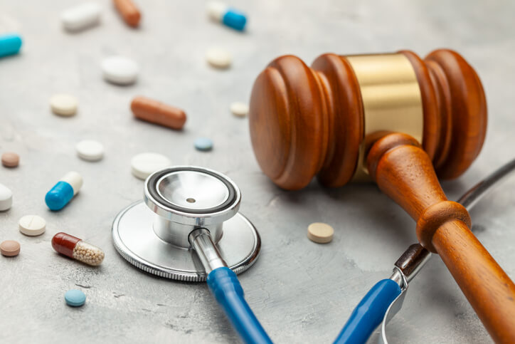 gavel with stethoscope and pills