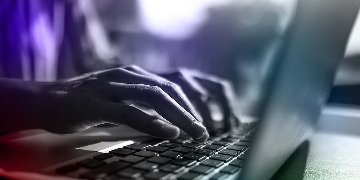 A pair of hands typing on a laptop computer keyboard.