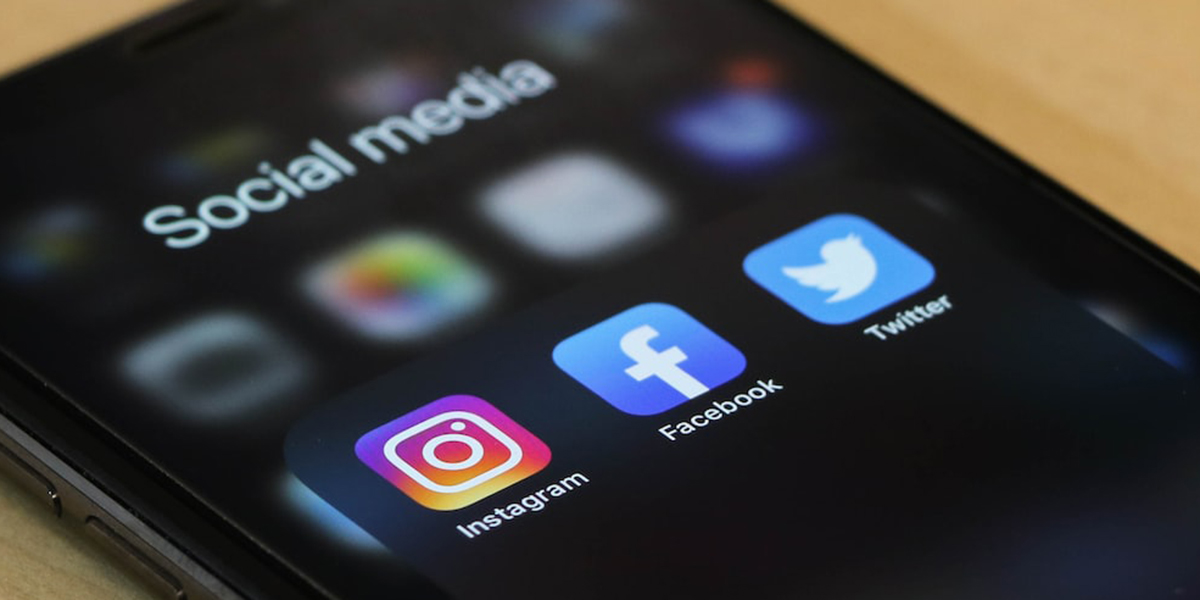 A cellphone screen displays the icons for popular social media apps