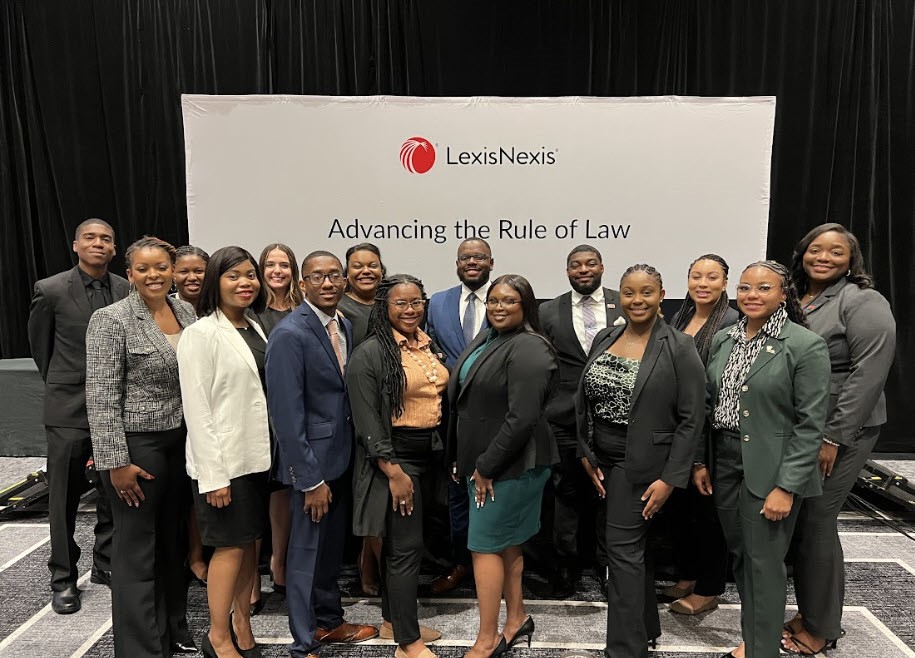 The 2023 cohort of LexisNexis Rule of Law Fellows pose in front of a banner that reads 