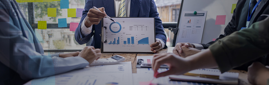 legal department financial management capabilities featured by four lawyers at a desk discussing budgets and profit and loss statements