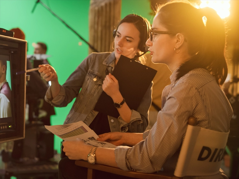 Producer and director talking and looking at a camera monitor
